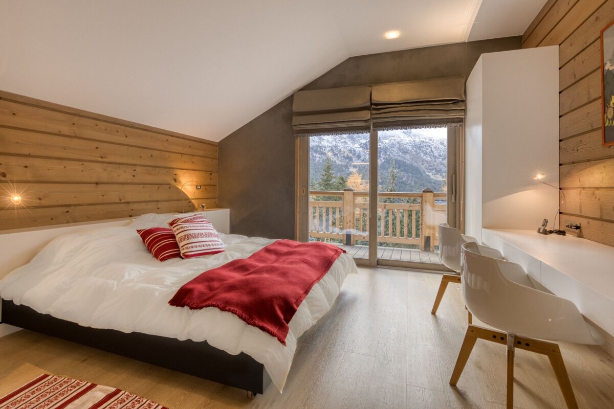 A bedroom with a sliding glass door leading to a balcony