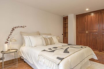 A bedroom with a bed with a blanket that says ' x ' on it