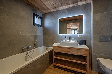 A bathroom with a bathtub a sink and a mirror