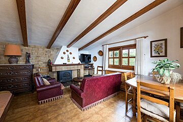 A living room with a red couch and a fireplace