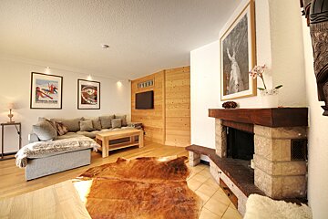 A living room with a couch and a fireplace with a poster on the wall that says ' switzerland '