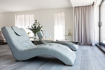 A lounge chair with a vase of flowers on it