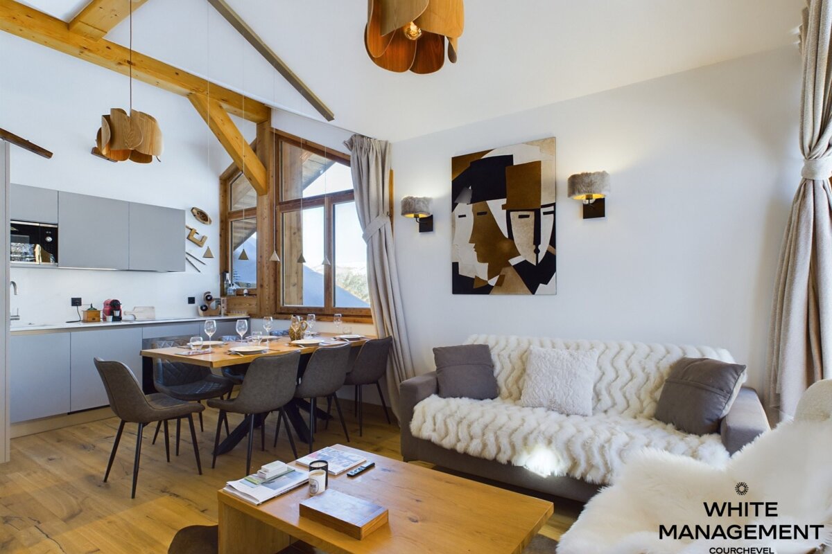 A kitchen with a table and chairs and a painting on the wall