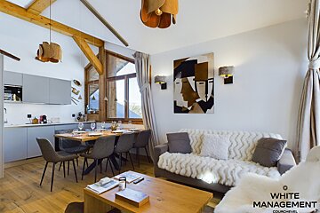 A kitchen with a table and chairs and a painting on the wall