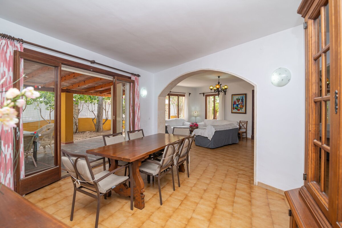 A dining room with a wooden table and chairs
