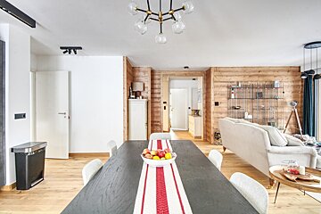 A dining room table with a bowl of fruit on it
