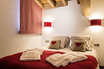 A bathroom with a sink and a bedroom with a bed