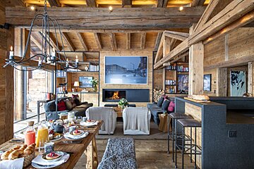 A living room with a dining table and a fireplace