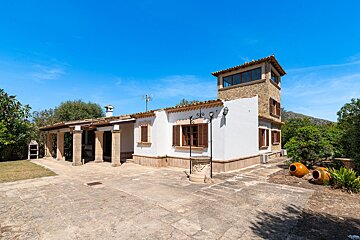 A white house with a stone tower on top of it