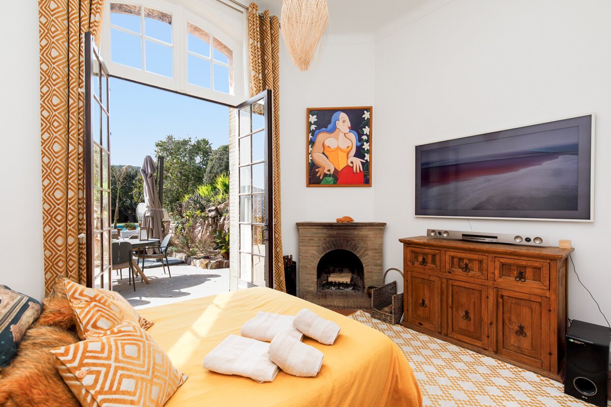 A bedroom with a fireplace and a flat screen tv
