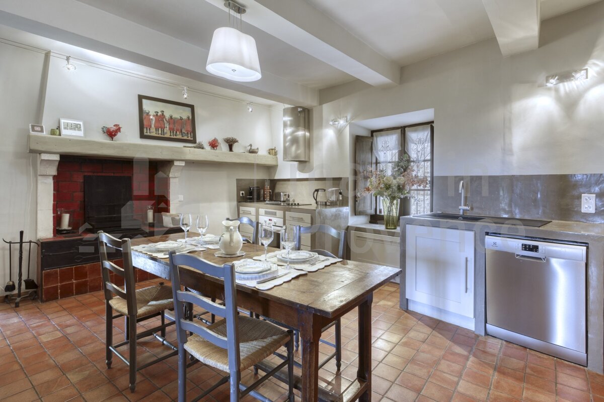 A kitchen with a wooden table and chairs and a stainless steel dishwasher