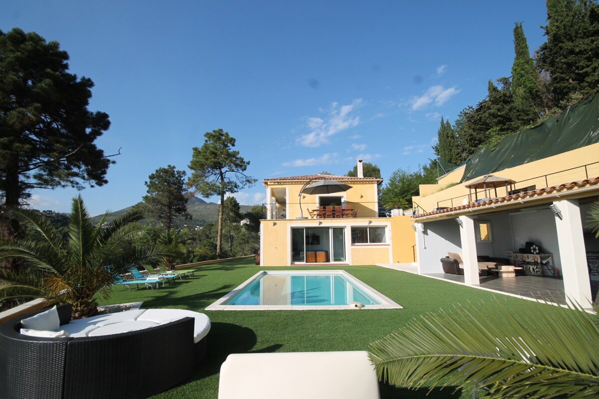 A large house with a swimming pool in front of it