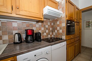 A kitchen with a laden washer and dryer