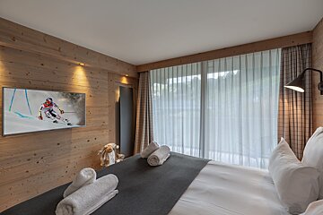 A bedroom with a flat screen tv showing a skier