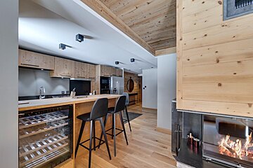 A kitchen with a wine cooler and a fireplace