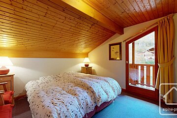 A bedroom with a bed and a picture on the wall that says alpine-pro