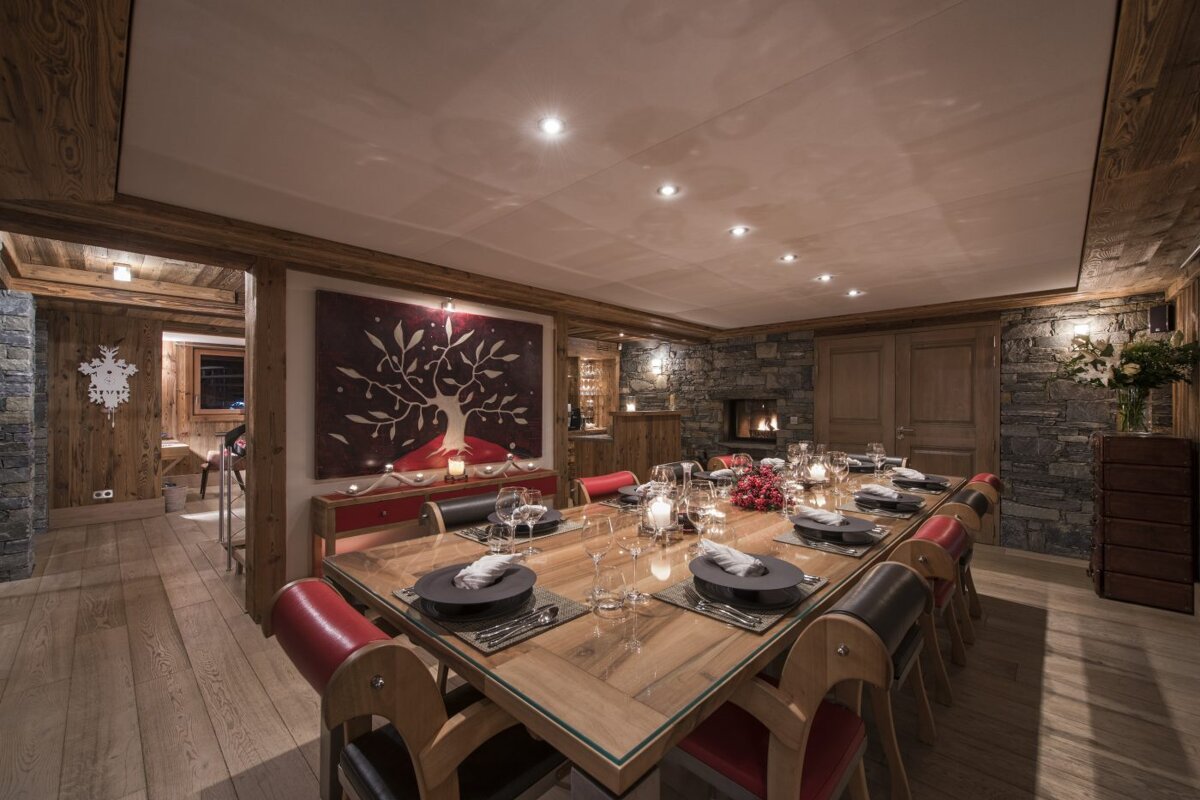 A dining room with a long wooden table and chairs
