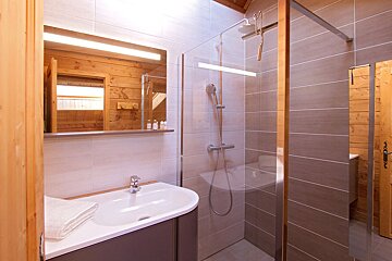 A bathroom with a sink and a walk in shower