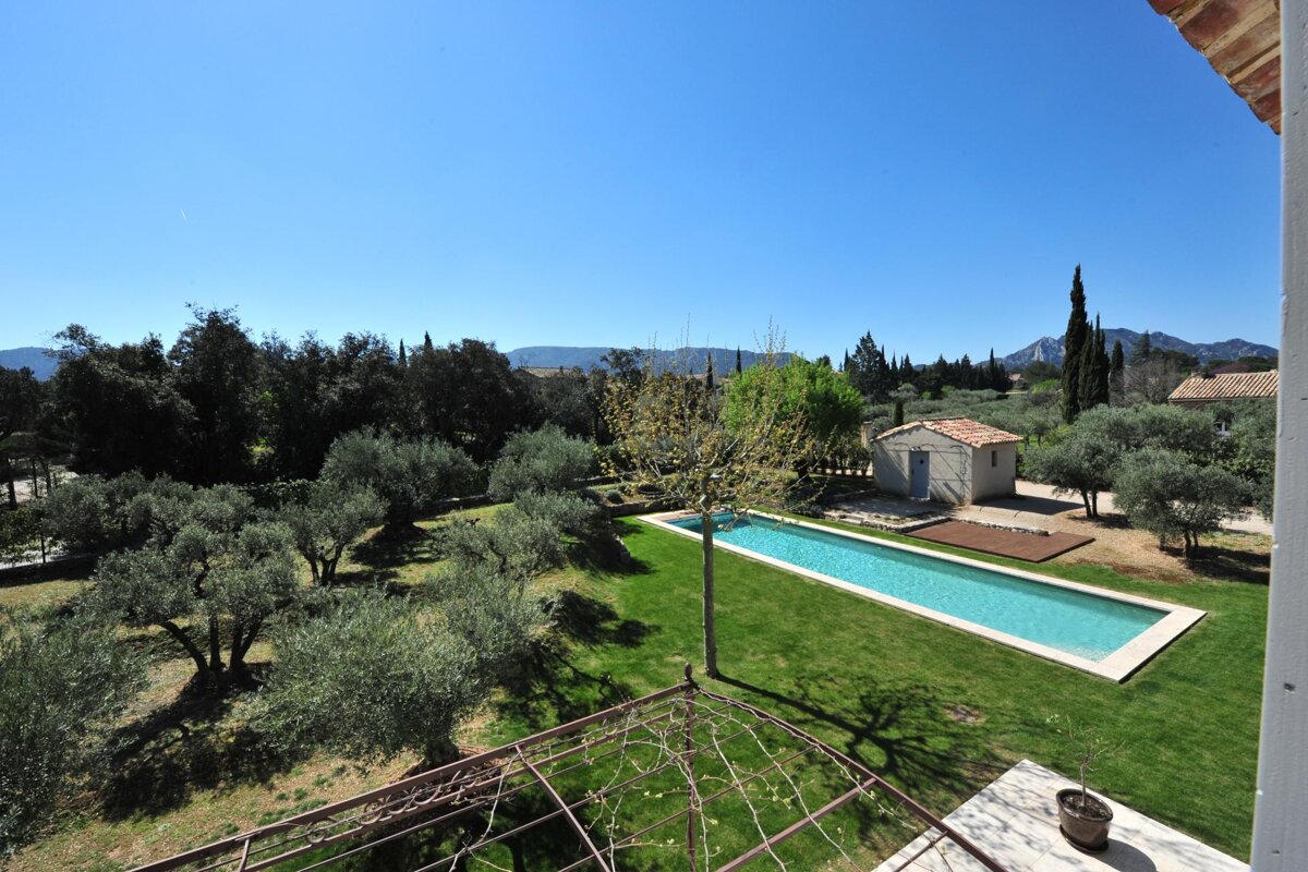 A large swimming pool surrounded by trees and mountains