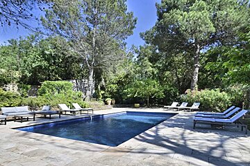 A large swimming pool surrounded by chairs and trees