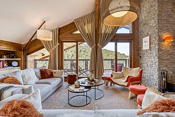 A living room with a couch and chairs and a large window