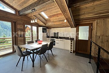 A kitchen with a table and chairs and the website immobilier.com