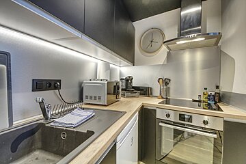 A kitchen with a clock on the wall that shows the time as 4:20