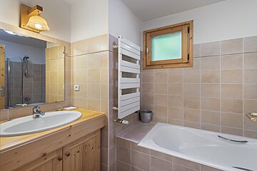 A bathroom with a sink and a bathtub and a window