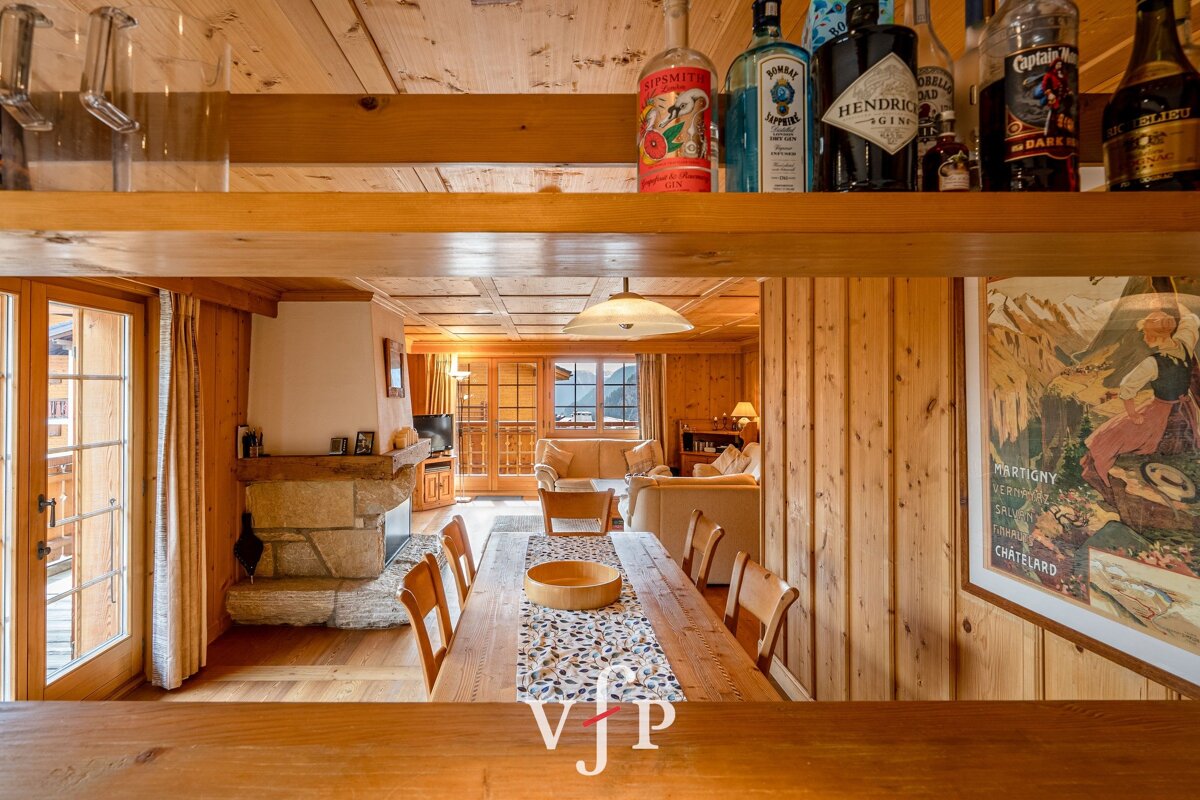 A bottle of hendrick 's gin sits on a wooden shelf