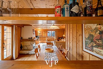 A bottle of hendrick 's gin sits on a wooden shelf