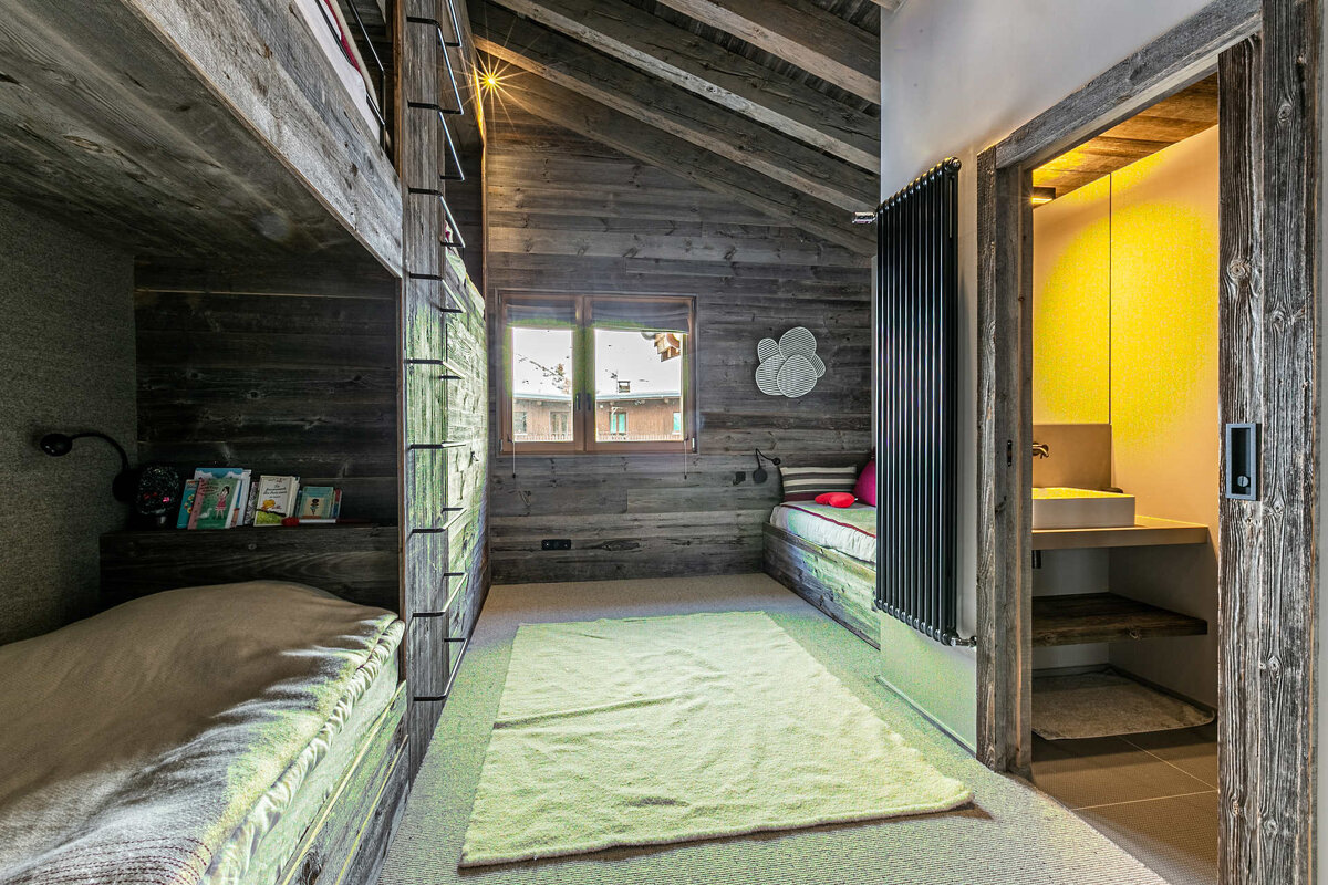 A bedroom with bunk beds and a yellow wall