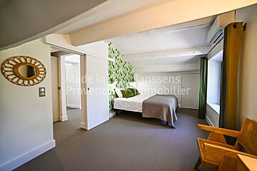 A bedroom with the words made in danssens provence immobilier on the wall
