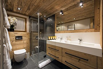 A bathroom with two sinks and a toilet