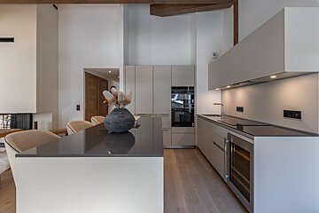 A kitchen with white cabinets and a black counter top