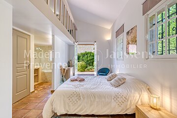 A bedroom with jaussens immobilier written on the wall