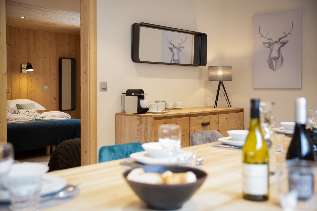 A bottle of wine sits on a wooden table