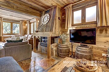A living room with a clock on the wall and a samsung television