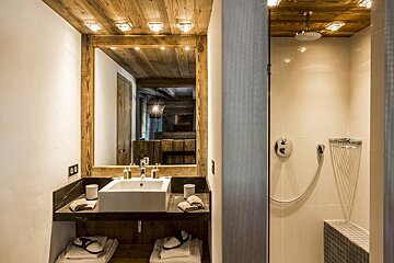 A bathroom with a sink a mirror and a shower
