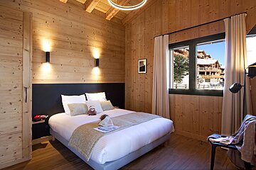 A bedroom with a large bed and a window