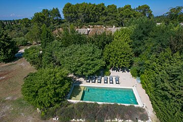An aerial view of a swimming pool surrounded by trees