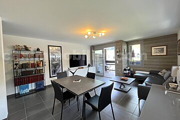 A living room with a table and chairs and a tv