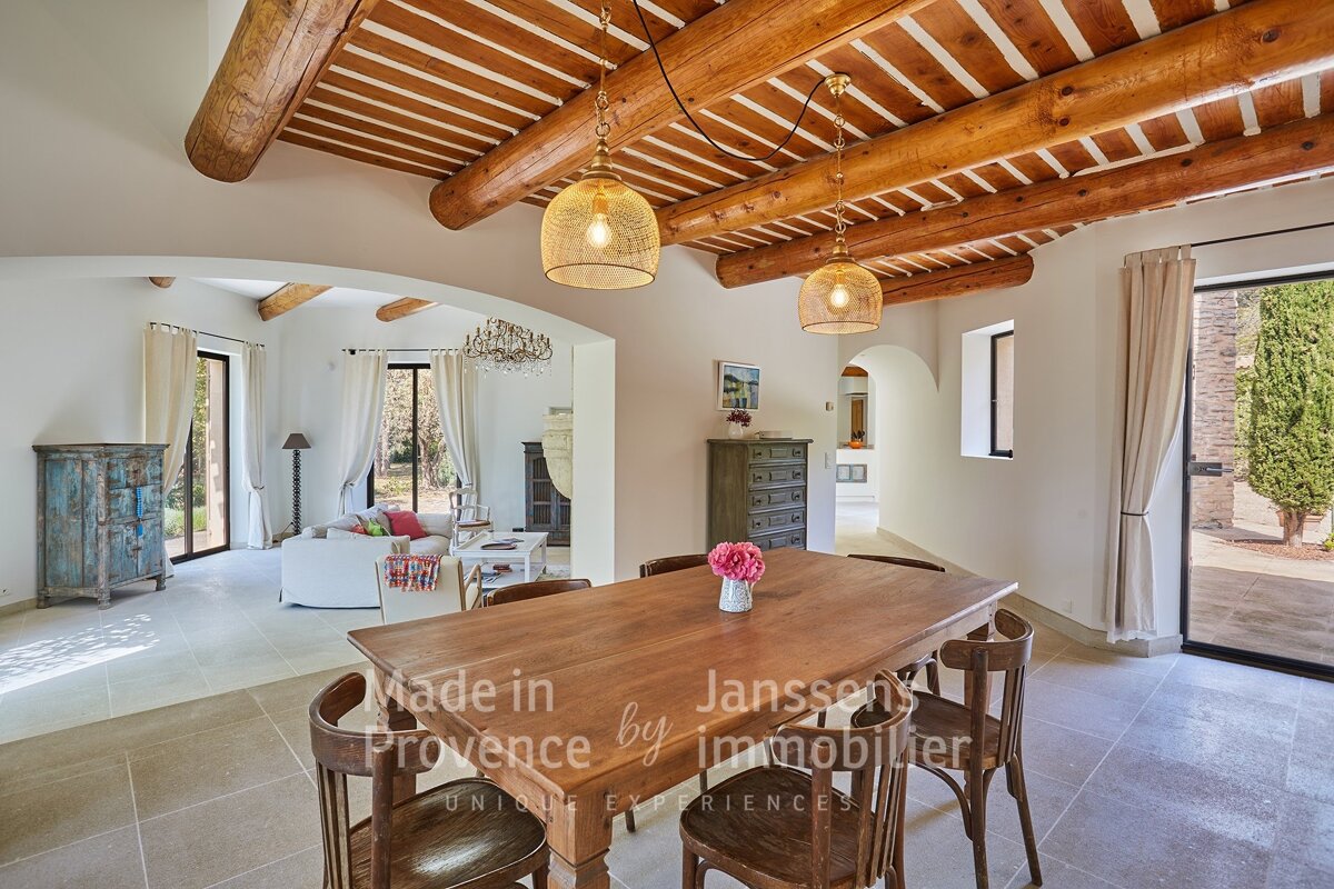 A dining room with a wooden table and chairs made in provence by janssens immobilier