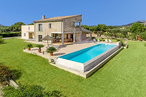 A large house with a large swimming pool in front of it