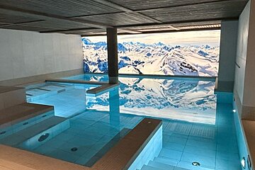 A swimming pool with a picture of mountains on the wall