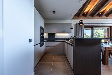 A kitchen with white cabinets and black counter tops