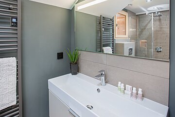 A bathroom with a sink a mirror and a towel rack