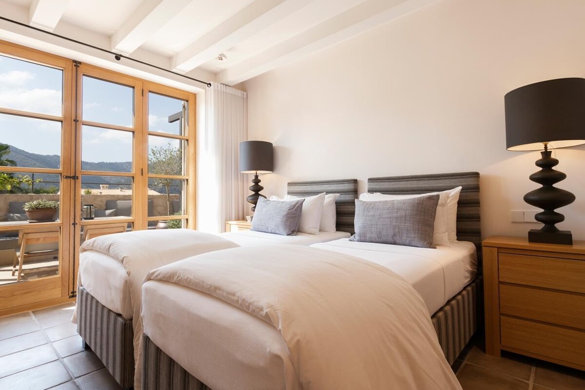 A bedroom with two twin beds and two lamps