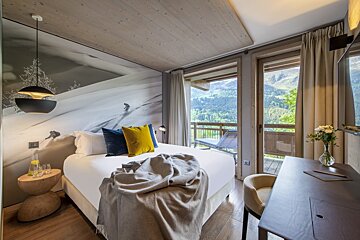 A hotel room with a bed and a desk