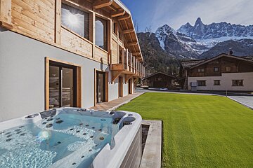 A hot tub in the snow with a mountain in the background