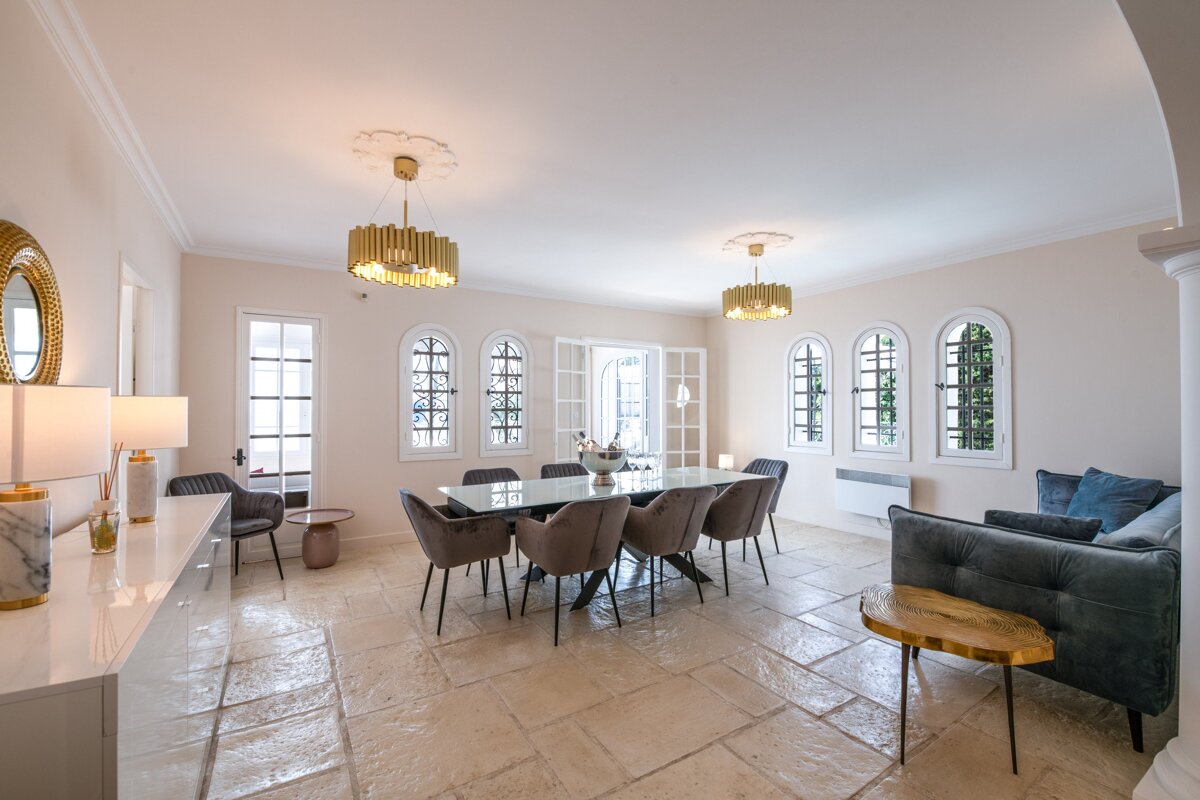 A dining room with a table and chairs and a couch